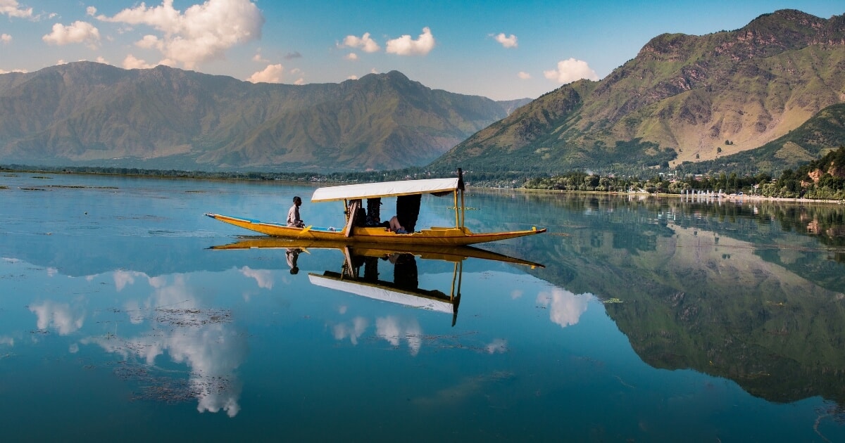 Srinagar Kashmir Dal Lake with a traditional Shikara boat surrounded by scenic Himalayan mountains